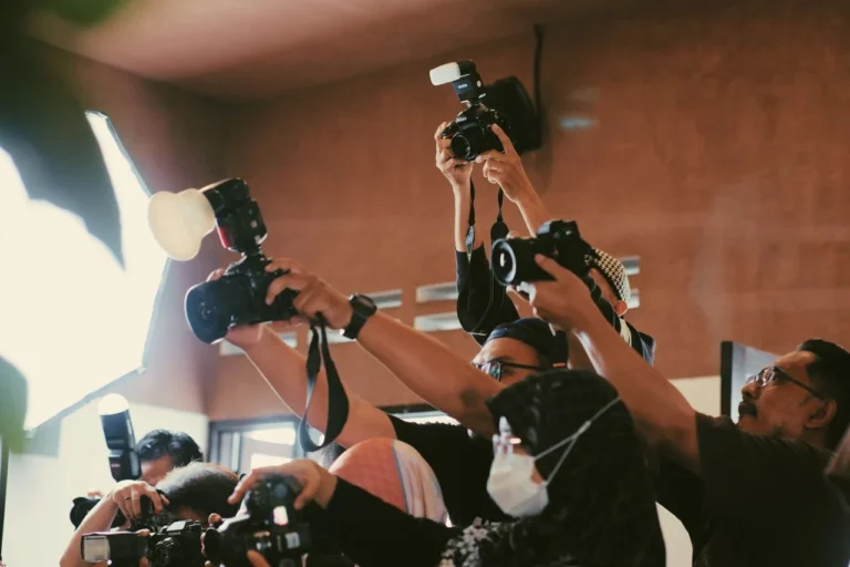 Photographers raising their cameras to shoot at an event