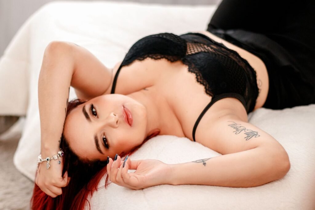 Boudoir portrait of a woman in black lingerie lying on a bed