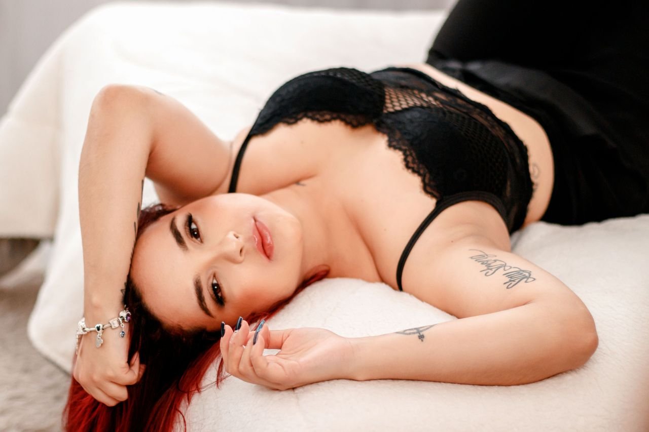 Boudoir portrait of a woman in black lingerie lying on a bed