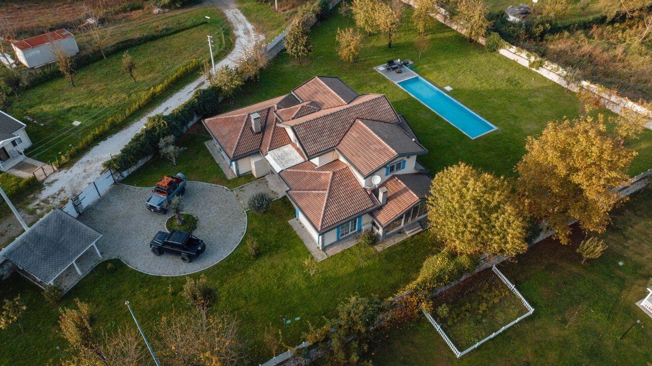 Aerial drone photo of a house with a pool and gardens