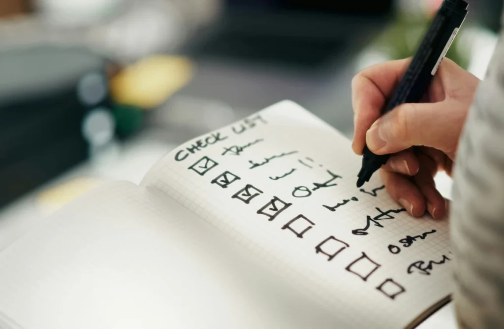 Hand writing a checklist in a notebook